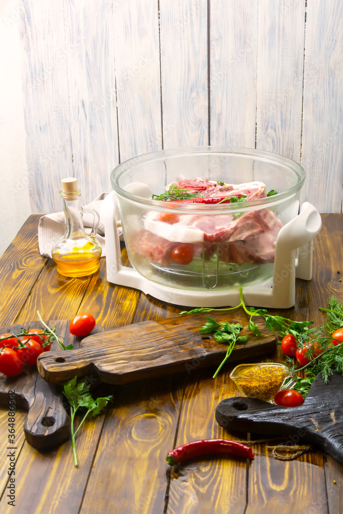 Electric convection oven on a wooden table. Cooking meat on an air grill. Fresh meat, wine and vegetables. Selective focus, place for text Electric convection oven on a wooden table. Cooking meat on an air grill. Fresh meat, wine and vegetables. Selective focus, place for text