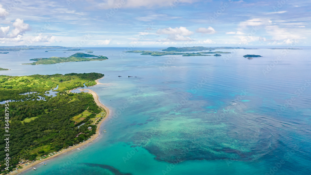 Malay archipelago with reefs and islands. Seascape with islands in the early morning, aerial drone. Beautiful landscape on the island of Luzon. Caramoan Islands, Philippines.