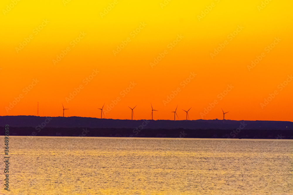Windmills in front of orange sunset Windmills in front of orange sunset