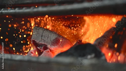 close up of some charcoal burning in a grill in slow motion