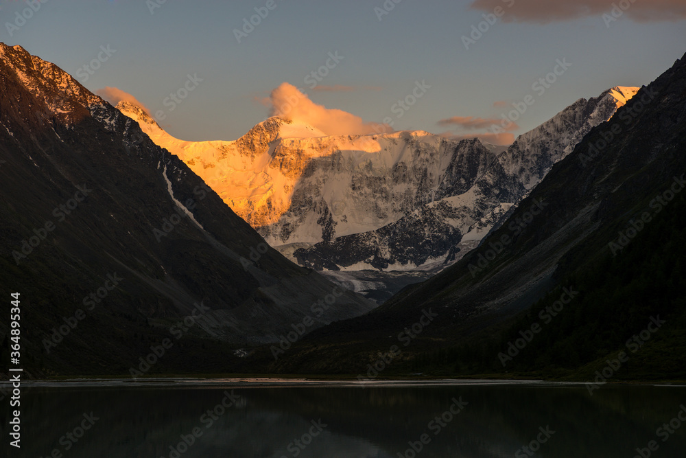 Belukha peak at sunset is reflected in the mountain lake AK-Kem