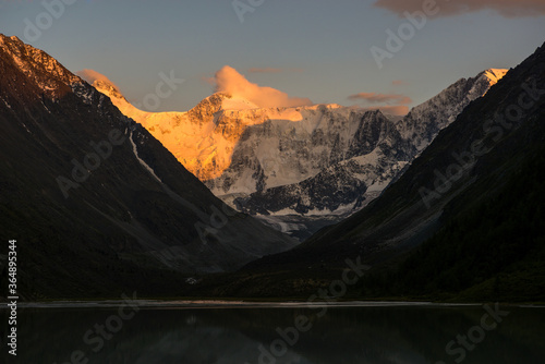 Belukha peak at sunset is reflected in the mountain lake AK-Kem