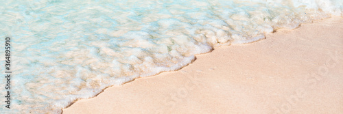 Beach sand ocean wave vacation summer background copy space of water tide over white sand texture. Turquoise ocean sea paradise travel vacation panoramic.