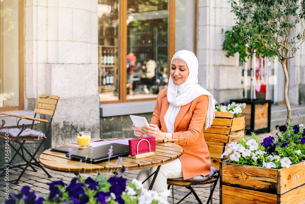 Beautiful young arabic girl in hijab working at street cafe. Beautiful young arabic girl in hijab working at street cafe.