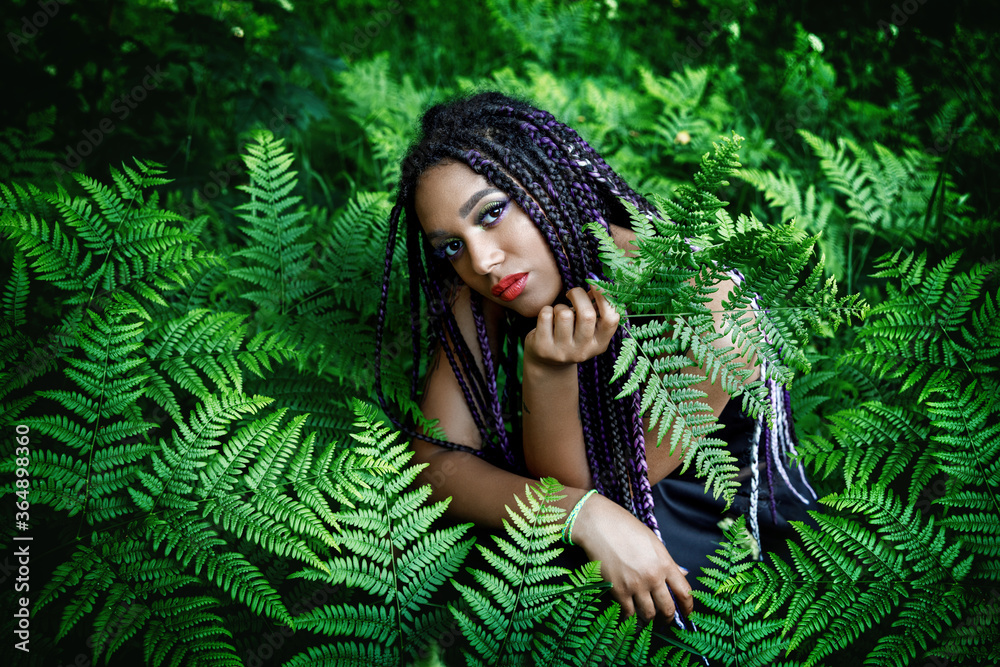 Portrait of a young beautiful girl with box braids hairstyle on the nature background Portrait of a young beautiful girl with box braids hairstyle on the nature background