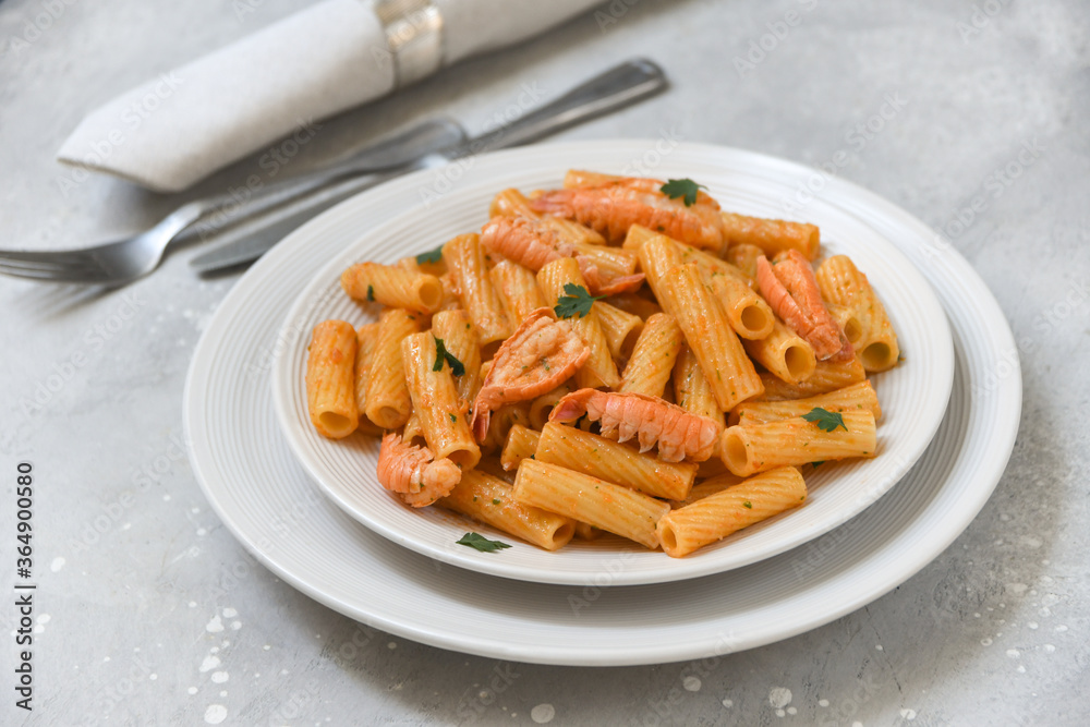 Penne pasta or Italian rigatoni with langoustines and tomato sauce in white plate top view. seafood pasta recipe Penne pasta or Italian rigatoni with langoustines and tomato sauce in white plate top view. seafood pasta recipe