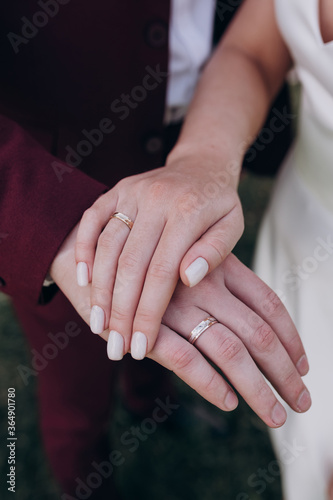 bride and groom with rings on their hands holding hands