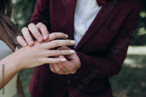 the groom puts a ring on the bride's finger