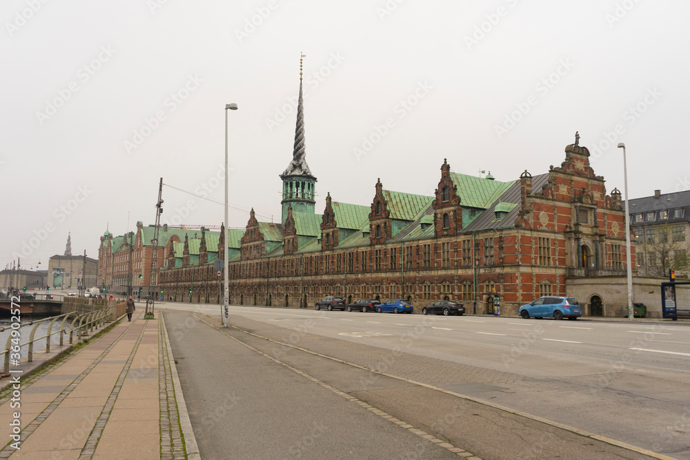Naklejka premium People walking in front of The magnificent Borsen building in winter evening in Copenhagen, Denmark