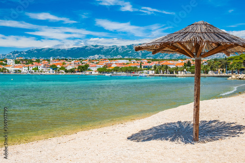 Adriatic sea shore in Croatia on Pag island  parasol on beautiful sand beach in town of Novalja 