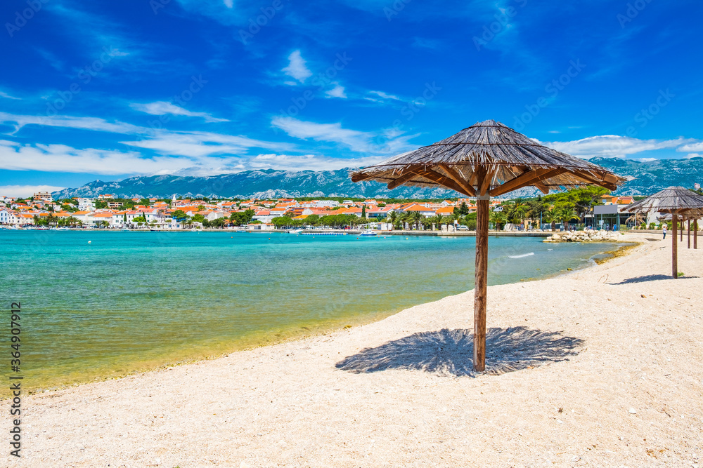 Obraz premium Adriatic sea shore in Croatia on Pag island, parasol on beautiful sand beach in town of Novalja 