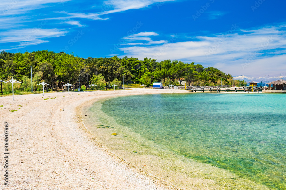 Adriatic sea shore in Croatia on Pag island, parasol on beautiful sand beach in town of Novalja
