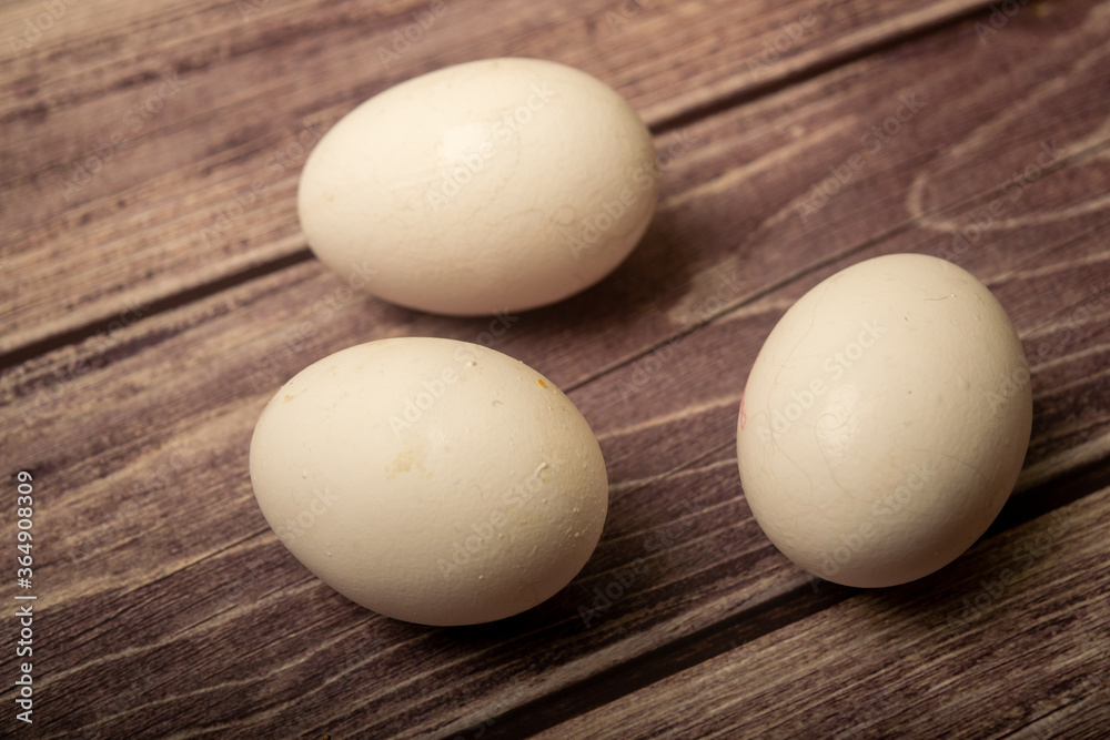 White chicken eggs on a wooden background. Close up. White chicken eggs on a wooden background. Close up.