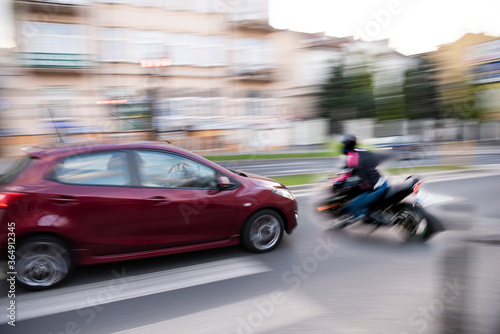 Dangerous city traffic situation with a motorcyclist and a car