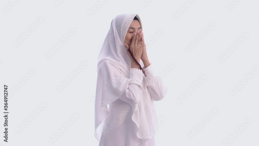 Muslim young woman praying open her arm isolated over white background Muslim young woman praying open her arm isolated over white background