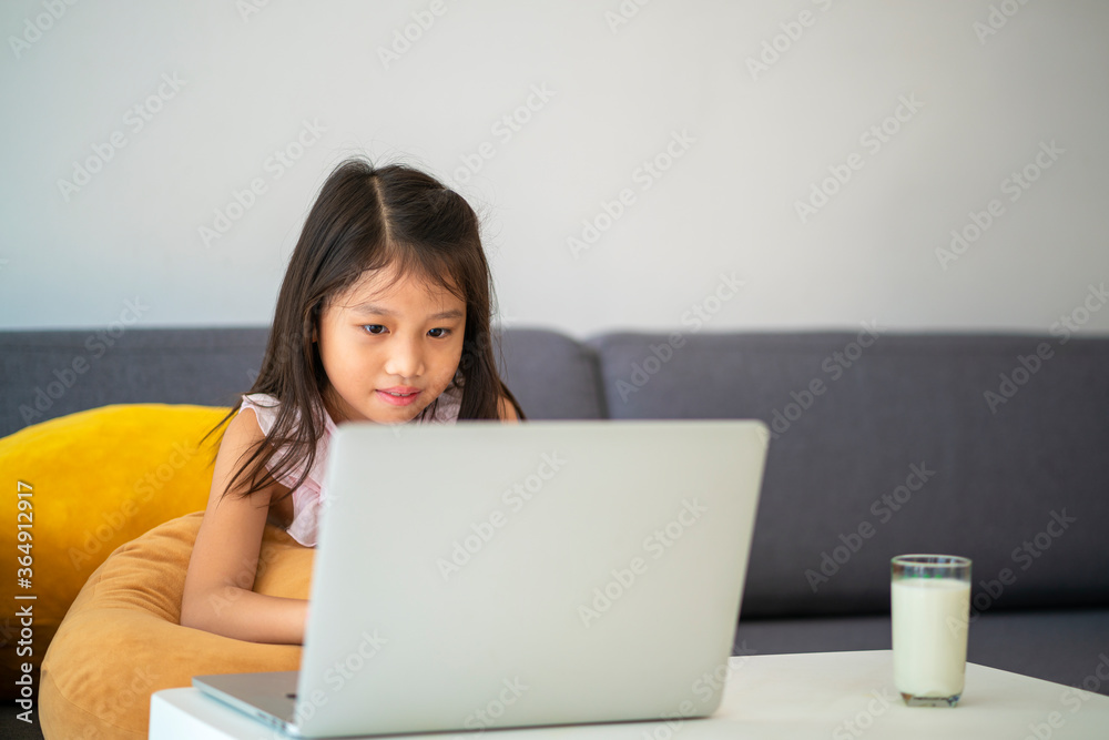 Asian girl using desktop computer for online study homeschooling during home quarantine. homeschooling, online study, home quarantine, online learning, corona virus or education technology concept Asian girl using desktop computer for online study homeschooling during home quarantine. homeschooling, online study, home quarantine, online learning, corona virus or education technology concept