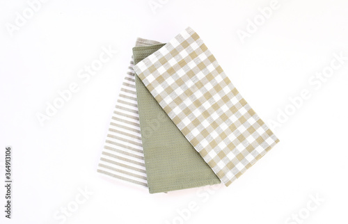 Top view new kitchen towels in green olives strip and white color simple pattern in differnet style on white background .Equipment necessary  in kithchen for wippe things.
