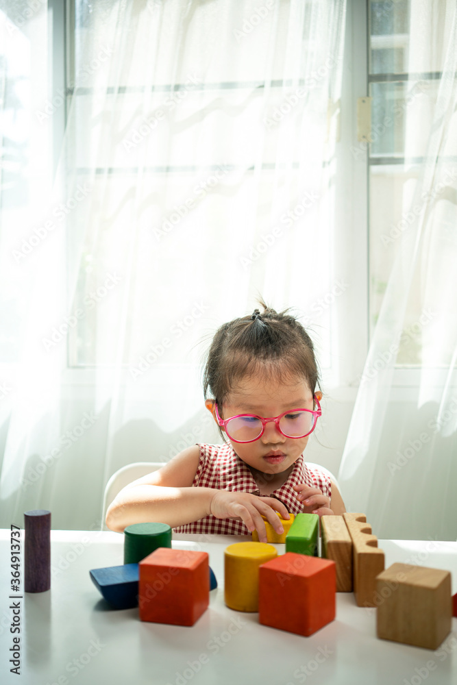 Asian girl playing wooden block in living room Asian girl playing wooden block in living room