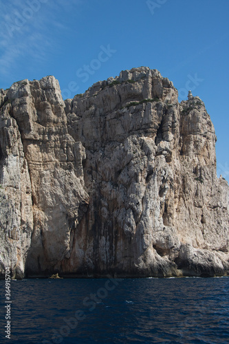 Rocky coast. Rocky wall overhanging the sea