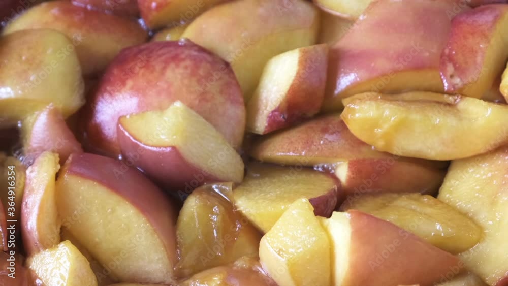 Cooking peach jam at home in an open pan in juice syrup close-up macro shot food moving background Cooking peach jam at home in an open pan in juice syrup close-up macro shot food moving background