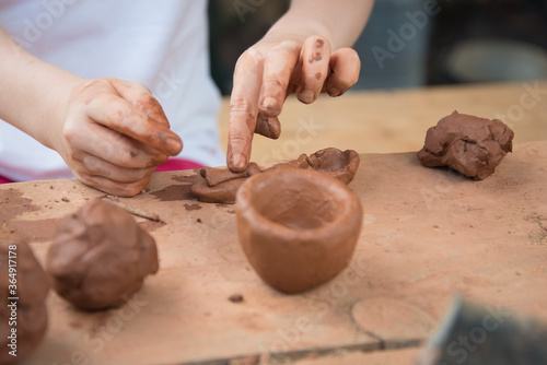 Close-up of children's hands working with clay. The child makes dishes and other crafts. Pottery. Concept of Hobbies and Hobbies, comprehensive development of the child.