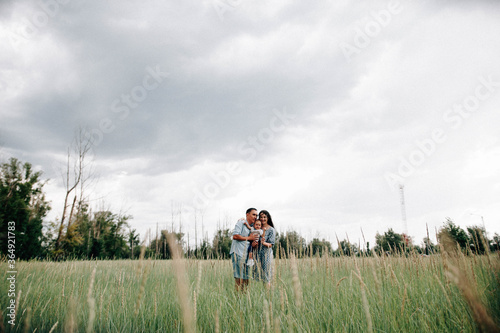 A happy family walks with a child in nature