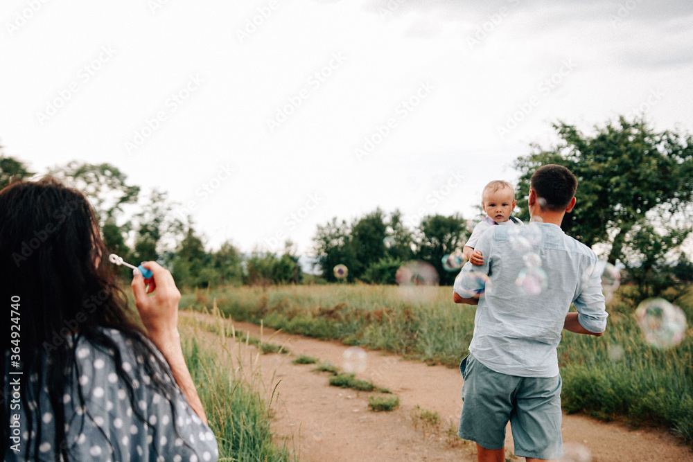 A happy family walks with a child in nature