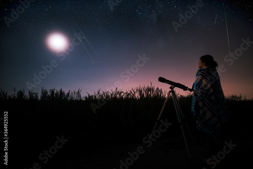 silhouette of a woman with a telescope