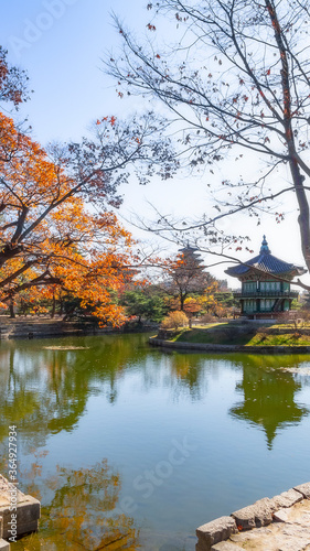Photography Vertical shot of an ancient asian public park with a lake and a small temple in