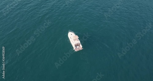 aerial video from a drone flying to the white yacht in the open sea 