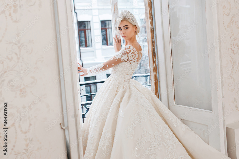 Bride in white dress, blonde girl posing in a photo studio. Vintage style interior. Bride in white dress, blonde girl posing in a photo studio. Vintage style interior.