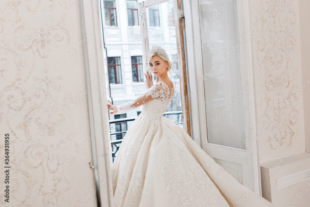 Bride in white dress, blonde girl posing in a photo studio. Vintage style interior. Bride in white dress, blonde girl posing in a photo studio. Vintage style interior.