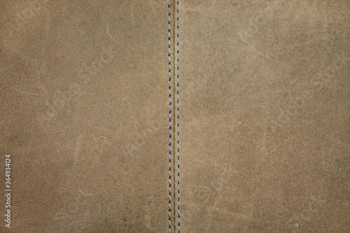 Texture of a beige natural leather with decorative stitching