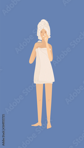 Young woman standing and holding cream in her hand and moisturizing her skin