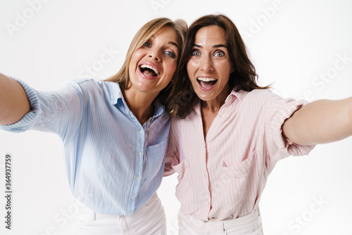 Image of delighted nice two women hugging while taking selfie photo