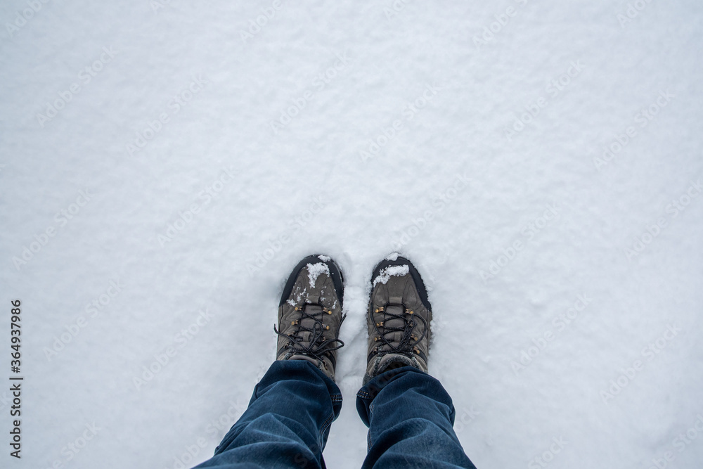 Male feet standing on the floor cover with snow in the winter. Male feet standing on the floor cover with snow in the winter.