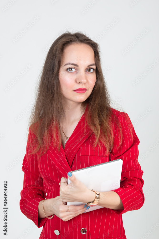 Portrait of a young business woman with beautiful eyes in a red suit and a tablet in her hands Portrait of a young business woman with beautiful eyes in a red suit and a tablet in her hands
