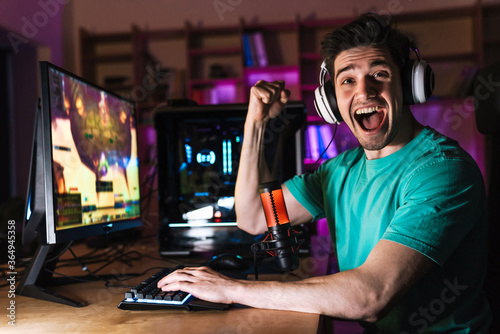 Image of excited man making winner gesture while playing video game © Drobot Dean