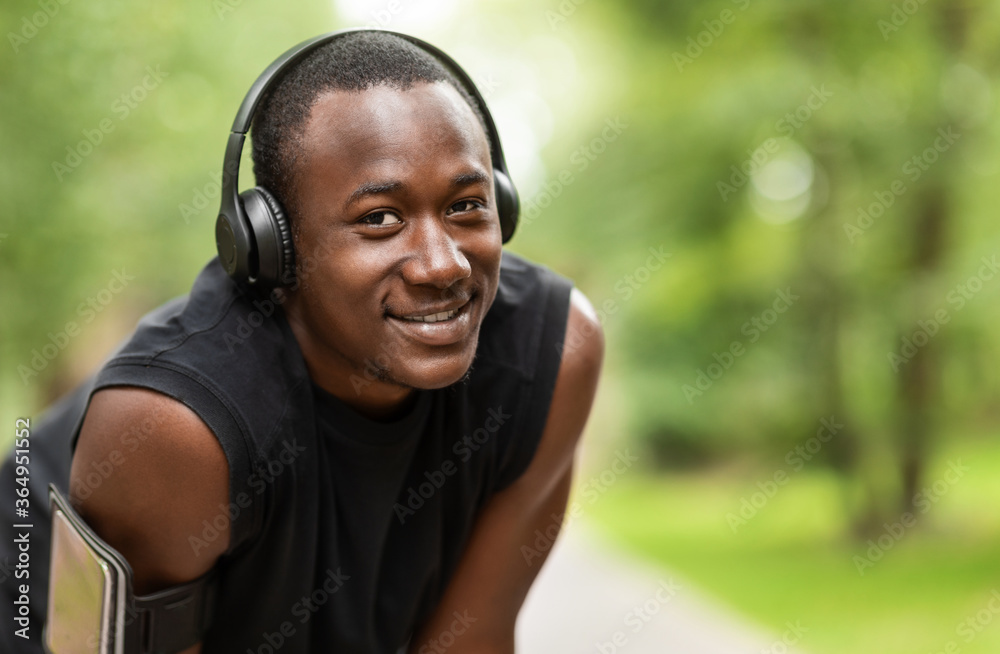 Fototapeta premium Closeup of cheerful black jogger with wireless headset