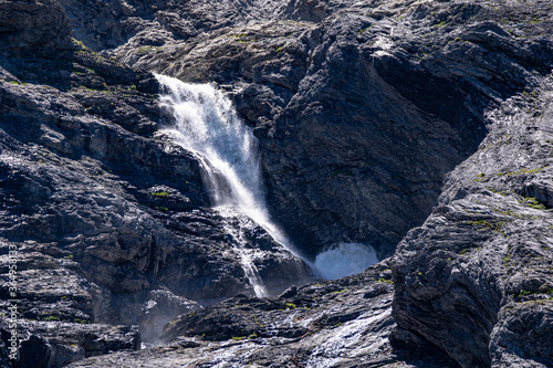 Melting glacier before blank rock with small river and snow. Schmelzender Gletscher Global Warming Rosenlaui Schweiz 