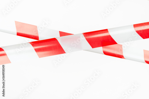Red and white restrictive tape on a white background. The tape is crossed, restriction