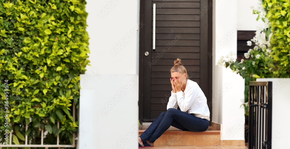 Portrait of  depressed  woman sitting on stairs at home.Crying woman