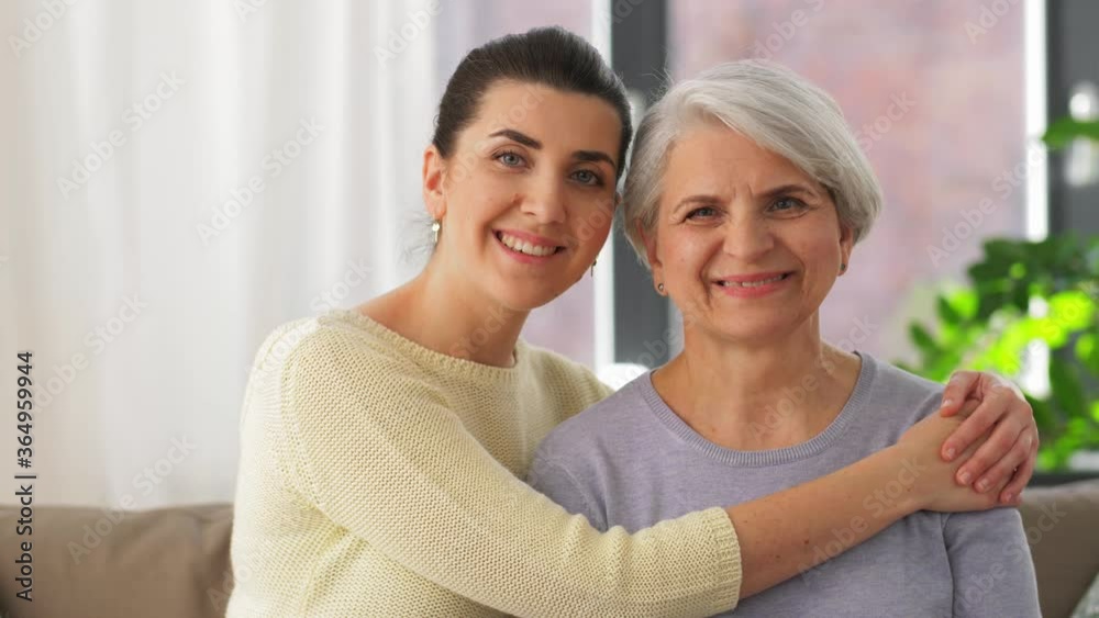 family, generation and people concept - happy smiling senior mother with adult daughter hugging at home family, generation and people concept - happy smiling senior mother with adult daughter hugging at home