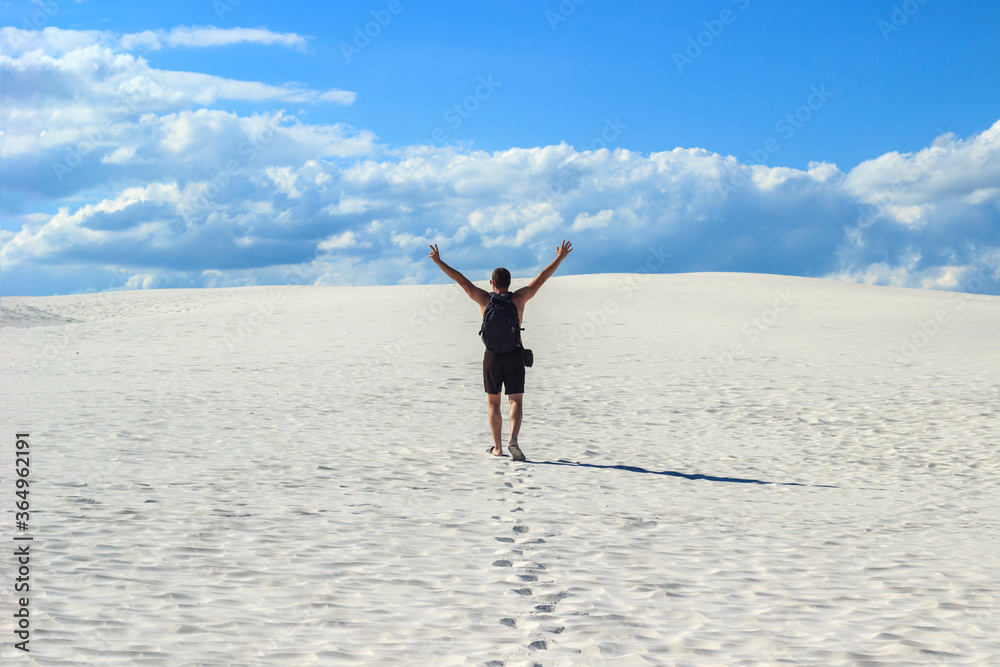 man joyfully raised his hands up while in the desert, far from civilization man joyfully raised his hands up while in the desert, far from civilization