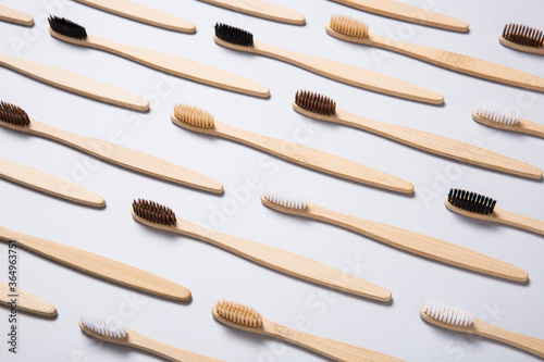 Bamboo toothbrushes arranged on grey background.