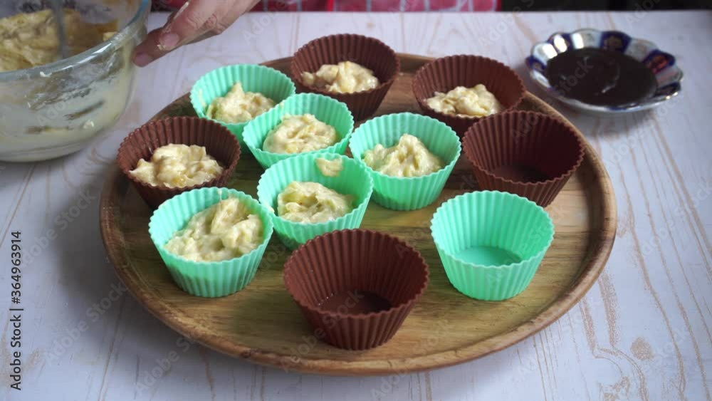 raw dough for banana cupcakes with chocolate in silicone molds, cooking home muffins raw dough for banana cupcakes with chocolate in silicone molds, cooking home muffins
