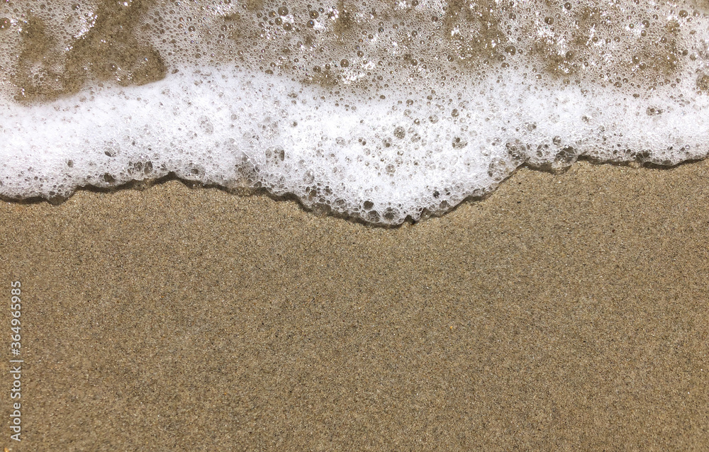 Close-up View of a Small Smooth Wave on a Beach in the Evening Close-up View of a Small Smooth Wave on a Beach in the Evening