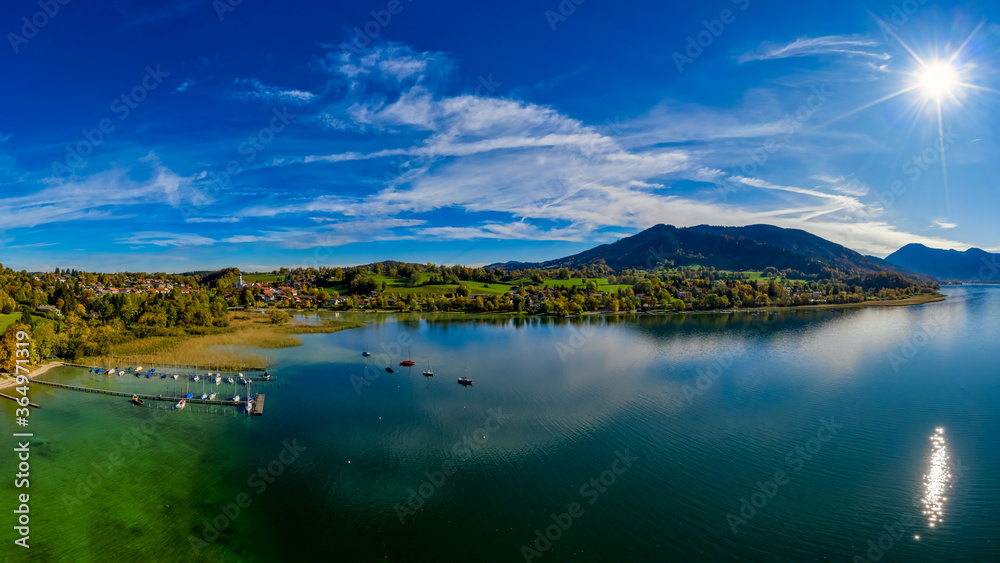 View over the beautyful landscape of the bavarian Tegernsee with boats at a web and the alp mountains in background.