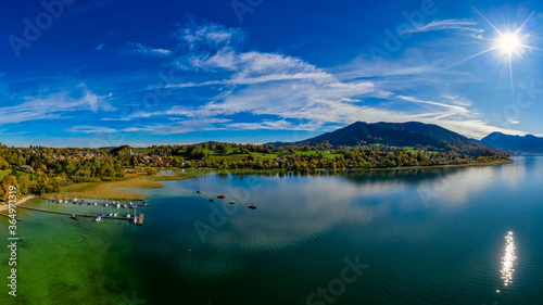 View over the beautyful landscape of the bavarian Tegernsee with boats at a web and the alp mountains in background.