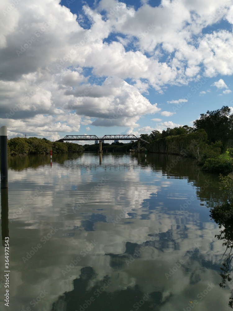 beautiful early morning view of river with reflections of blue sky, clouds, bridge and trees on water, Parramatta river, Rydalmere, New South Wales, Australia beautiful early morning view of river with reflections of blue sky, clouds, bridge and trees on water, Parramatta river, Rydalmere, New South Wales, Australia